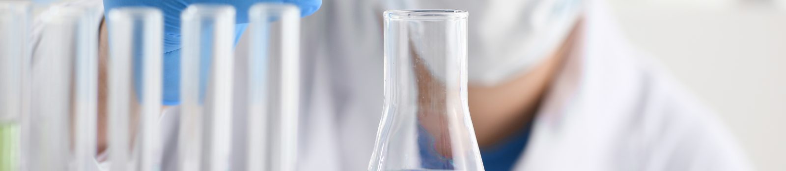 En kemist håller en pipett mot ett glas