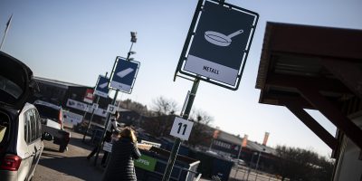 Skyltar på återvinningscentralen och kund på rampen