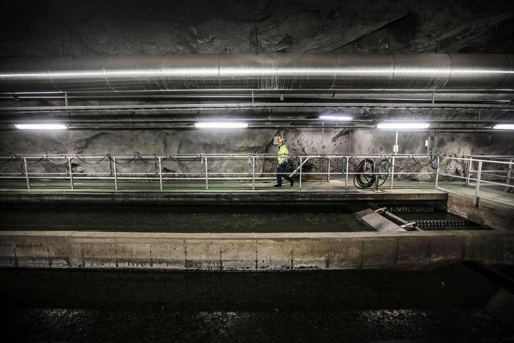 Tjej går i vid avloppsvatten i bergrum