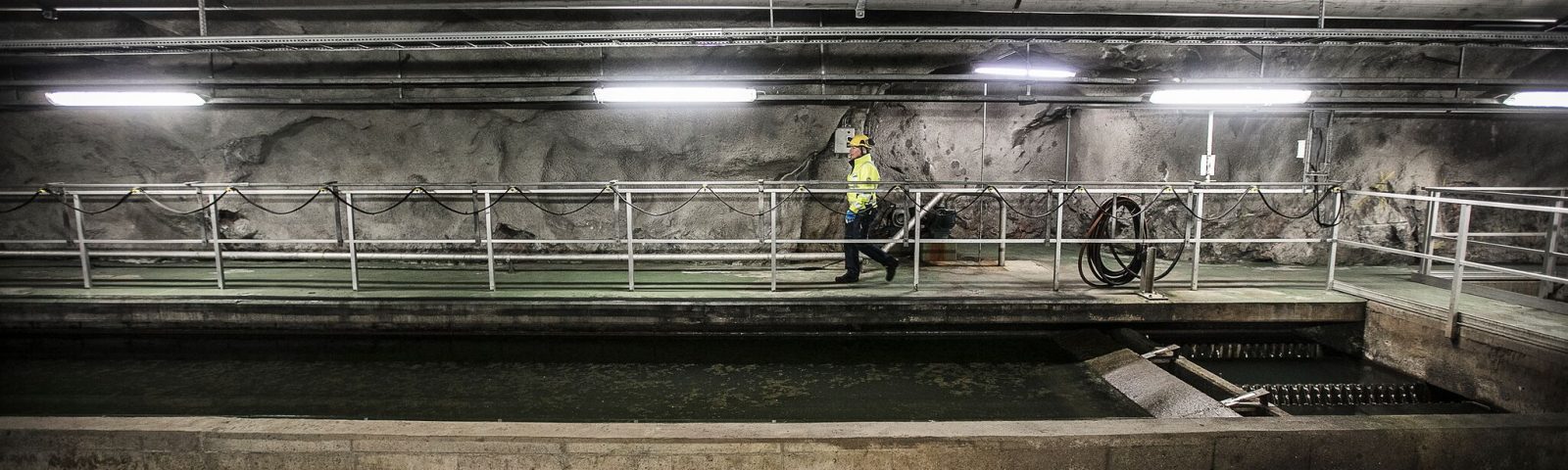 Tjej går i vid avloppsvatten i bergrum