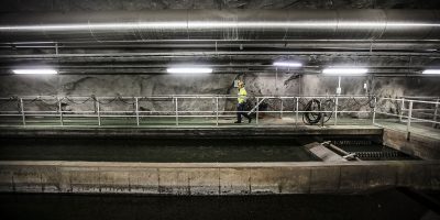 Tjej går i vid avloppsvatten i bergrum