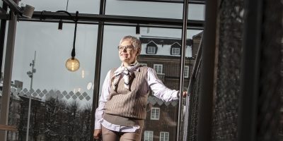 Kvinna står vid trappa och blickar bort