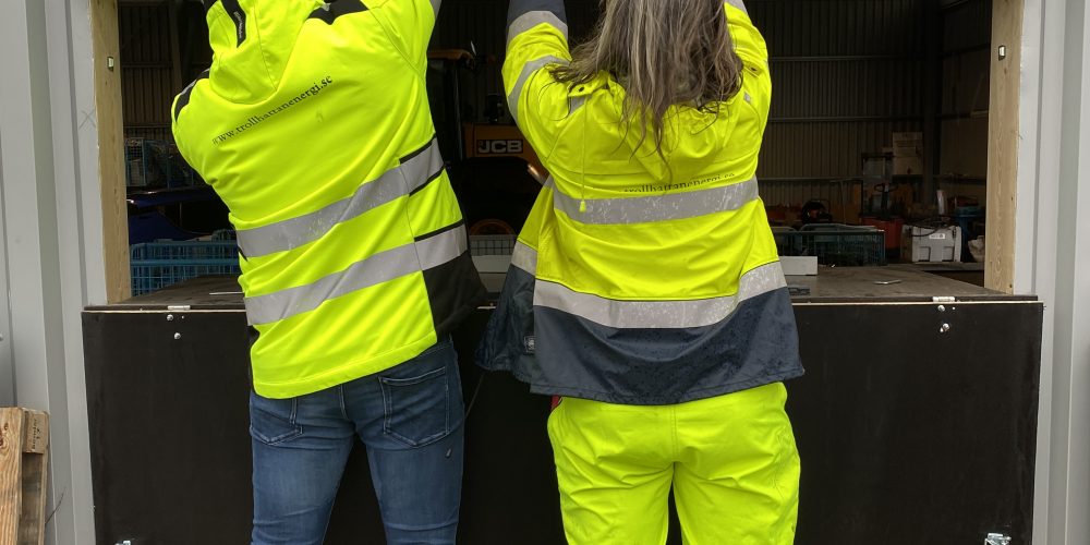 Två personer monterar upp en skylt