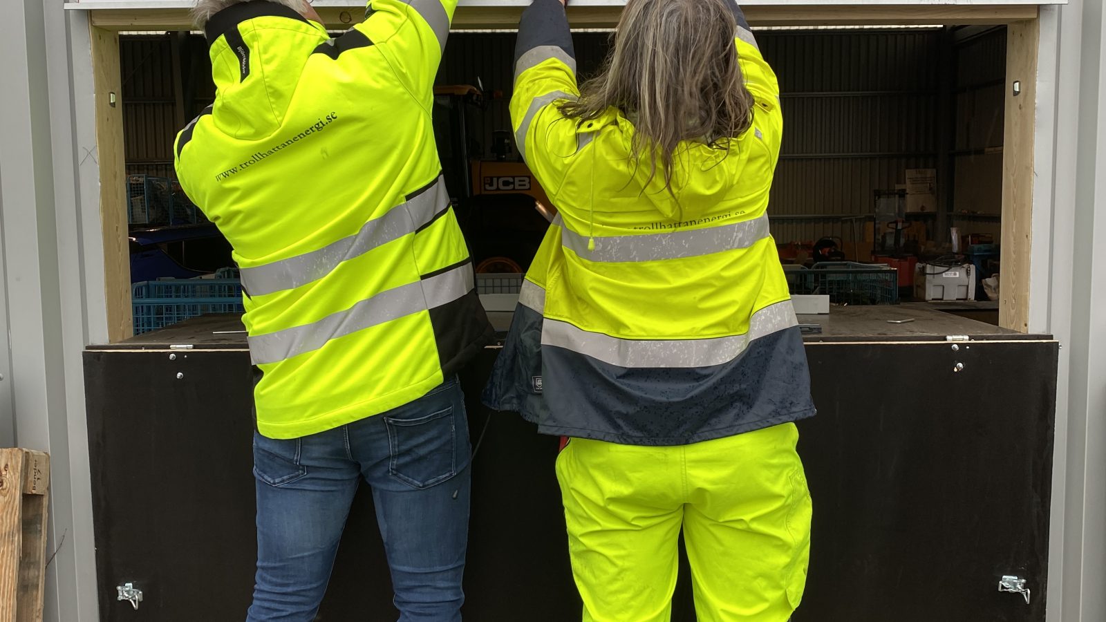 Två personer monterar upp en skylt