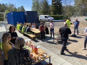 Gruppbild på människor som äter och minglar i solen