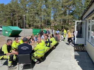 Många personer som äter och pratar utomhus i solen