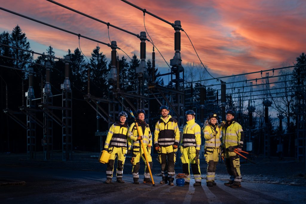 En grupp distributionselektriker framför ett ställverk