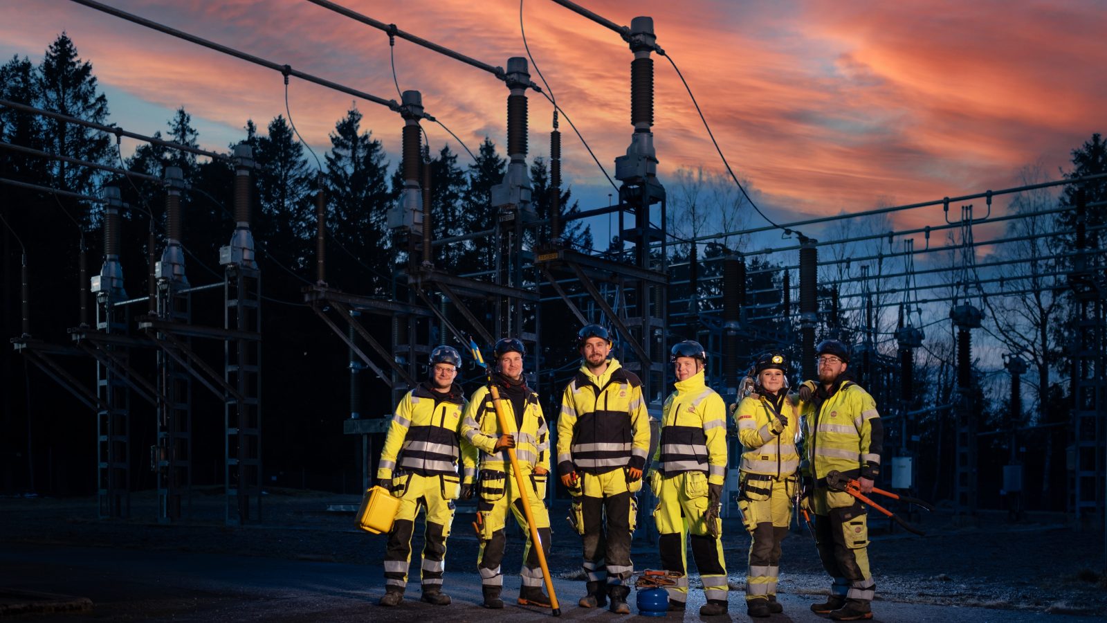 En grupp distributionselektriker framför ett ställverk