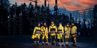 En grupp distributionselektriker framför ett ställverk