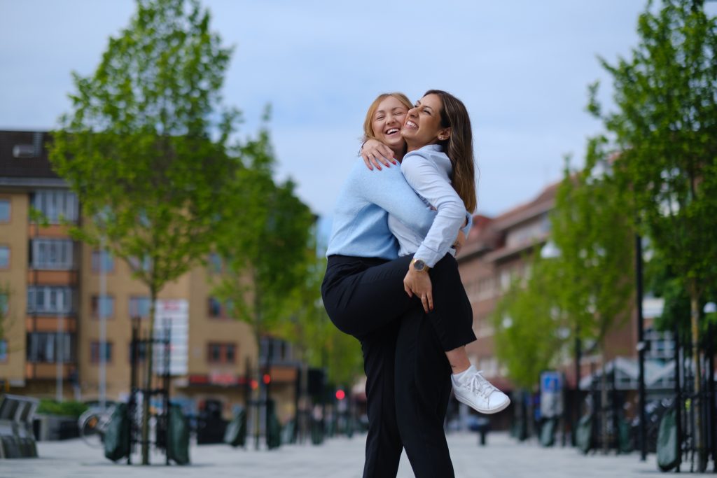 Två tjejer kramas hårt ute på stan