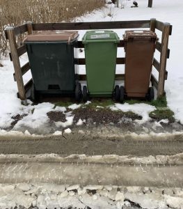 Tre sopkärl står framskottade ur snön