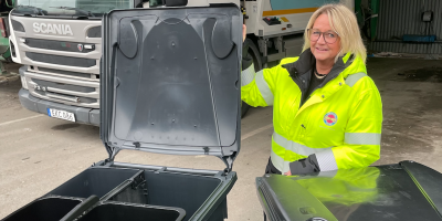 Tjej håller i locket på ett fyrfackssopkärl och visar