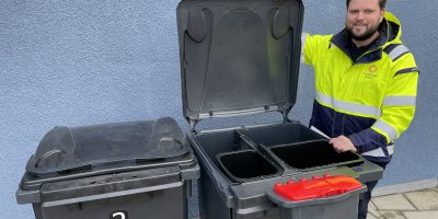 Kille visar upp två sopkärl med fyra fack i varje.