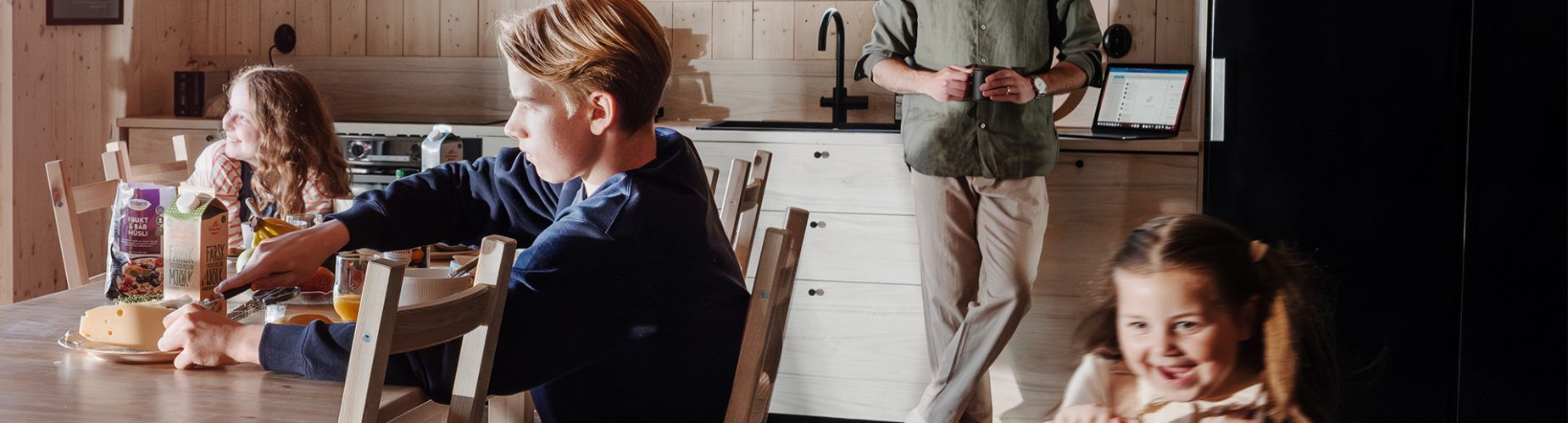 Familj i köket som äter frukost