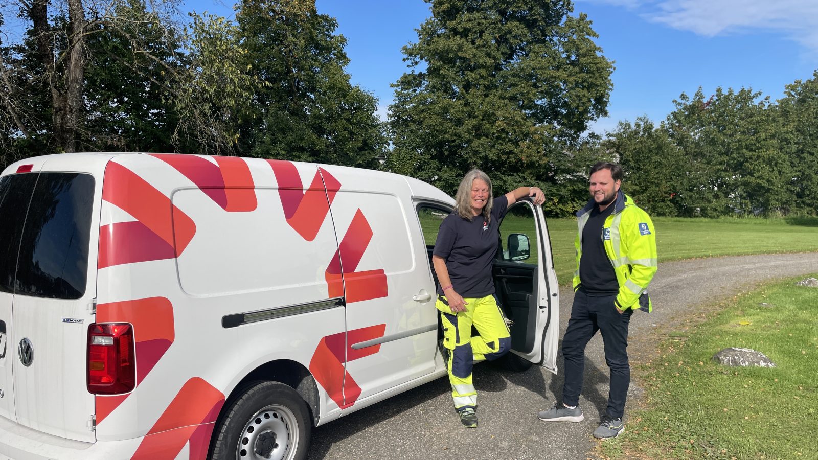 Kvinna och man står vid en Trollhättan Energibil i arbetskläder