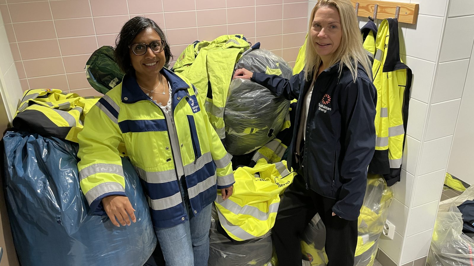 Sandra och Anna står framför säckar med arbetskläder.