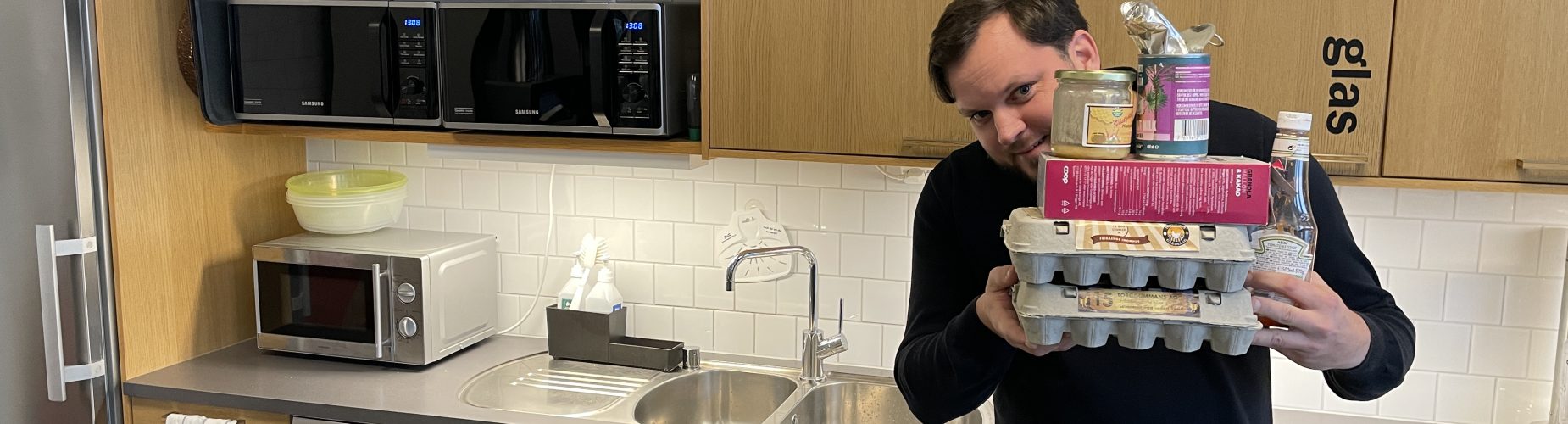 Man håller förpackningar i kök.