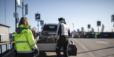 Personal på återvinningscentralen hjälper kund som lastar av sin kärra